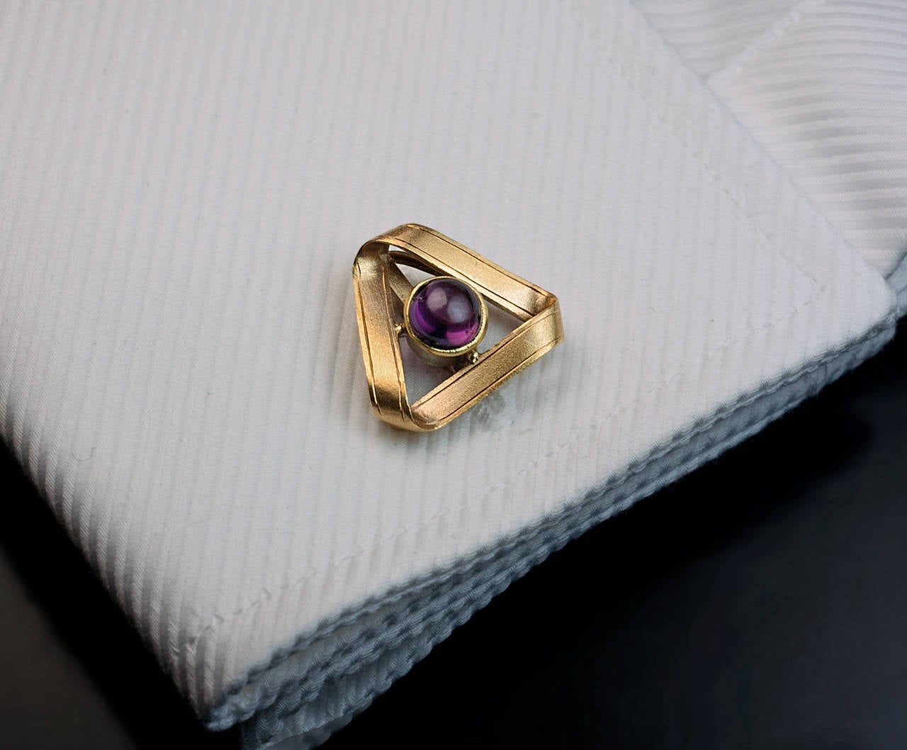 made in Moscow between 1908 and 1917

These unusual cufflinks are designed as twisted gold ribbons forming eternity triangles with bezel-set cabochon-cut rhodolite garnets in their centers.

Width 19 mm (3/4 in.)

Marked with 56 gold standard