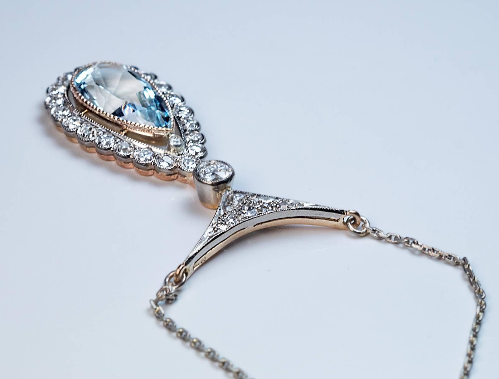 Russian, made in St. Petersburg in the 1930s

The 14K white and yellow gold necklace is set with a drop shaped aquamarine (16 x 8 x 5.25 mm, approximately 3.31 ct) framed by sparkling bright white (G-H color) diamonds (mostly old European cut).