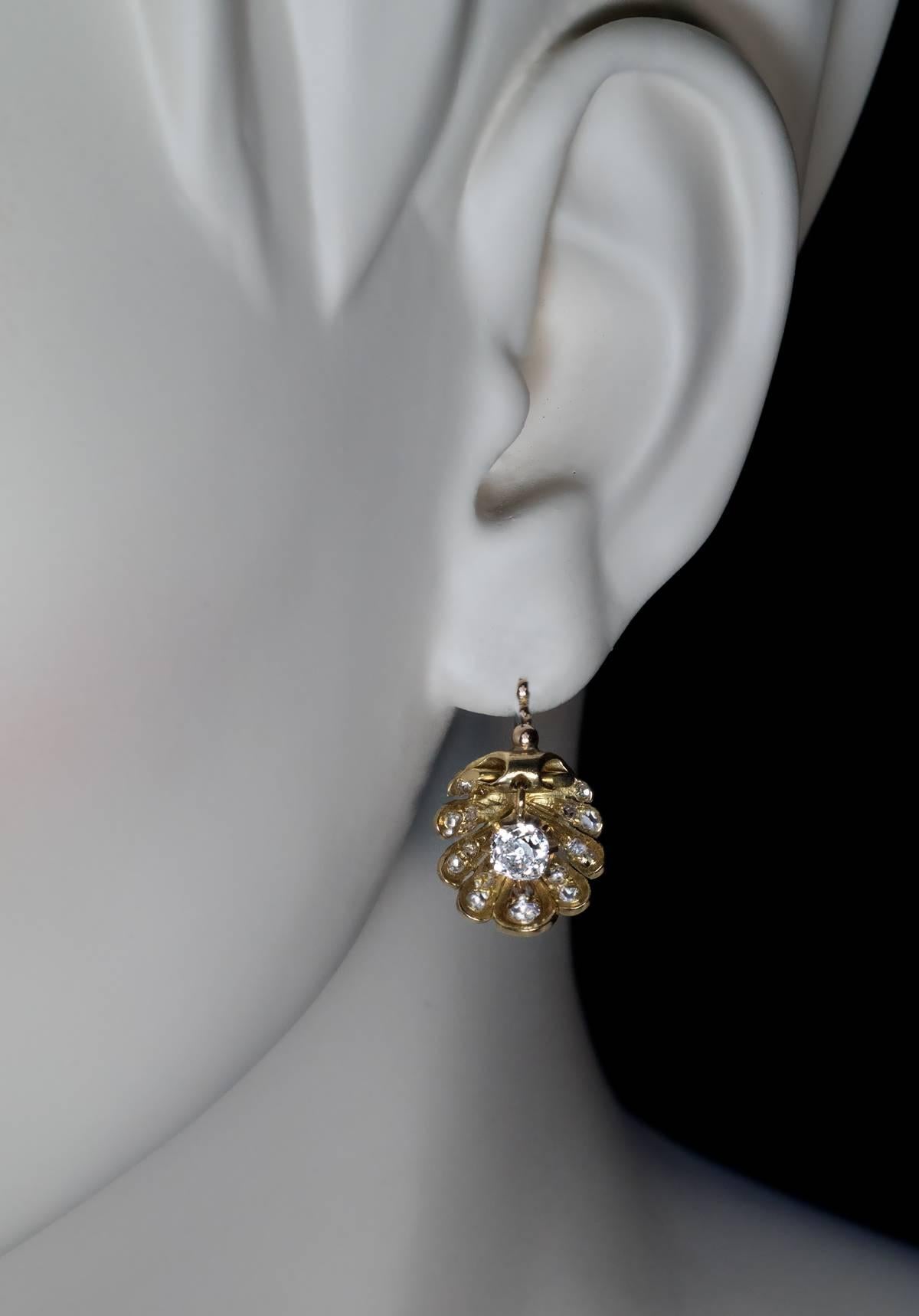 18K gold shell shaped earrings embellished with rose cut diamonds, each with a dangling cushion cut diamond (approximately 0.65 ct) in the center