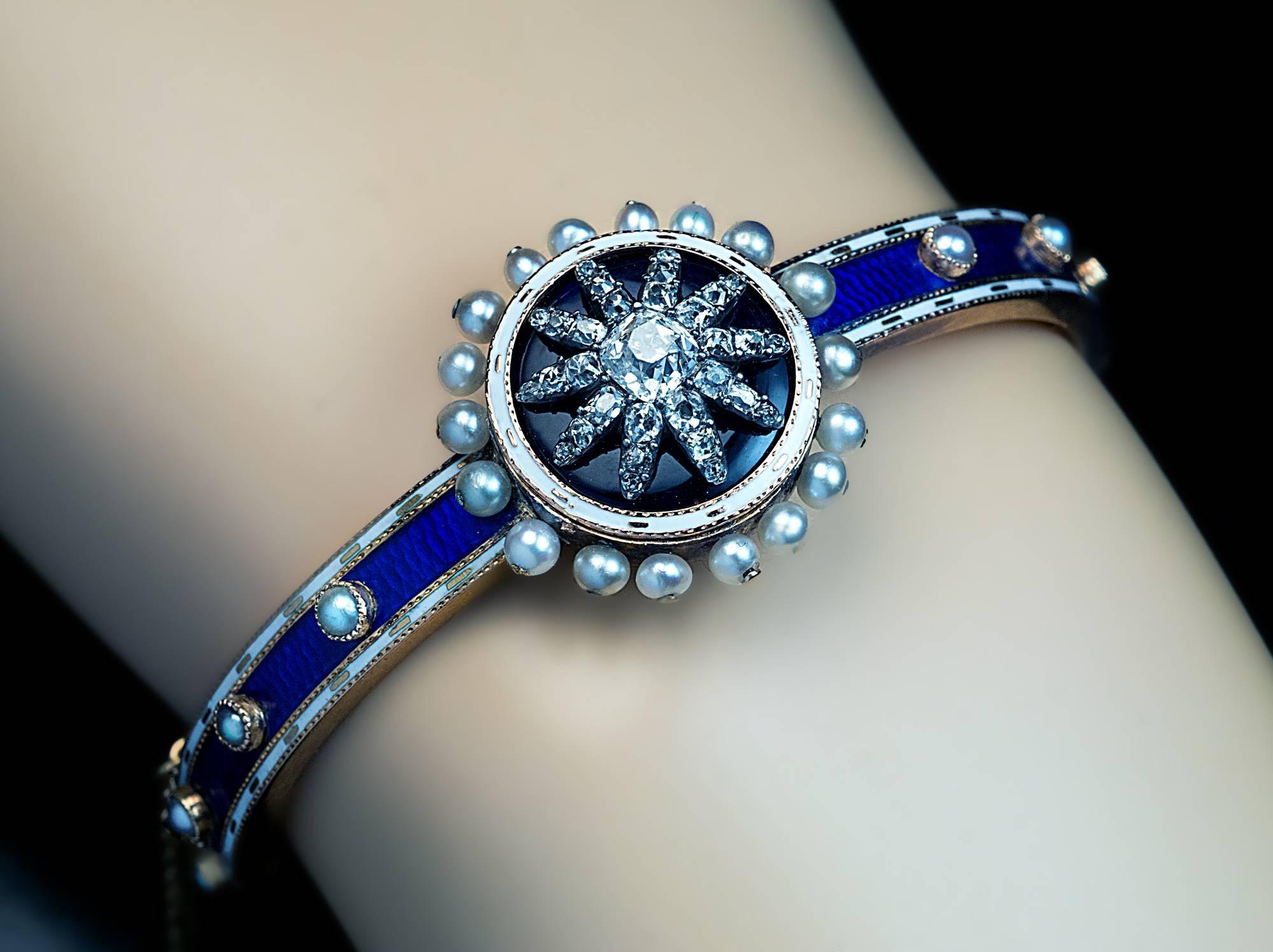 Circa 1800

A neo-classical 14K gold bangle bracelet centered with a round medallion embellished with a diamond-set silver star on a cobalt blue enamel ground within an opaque white enamel frame surrounded by a row of natural pearls.

The star