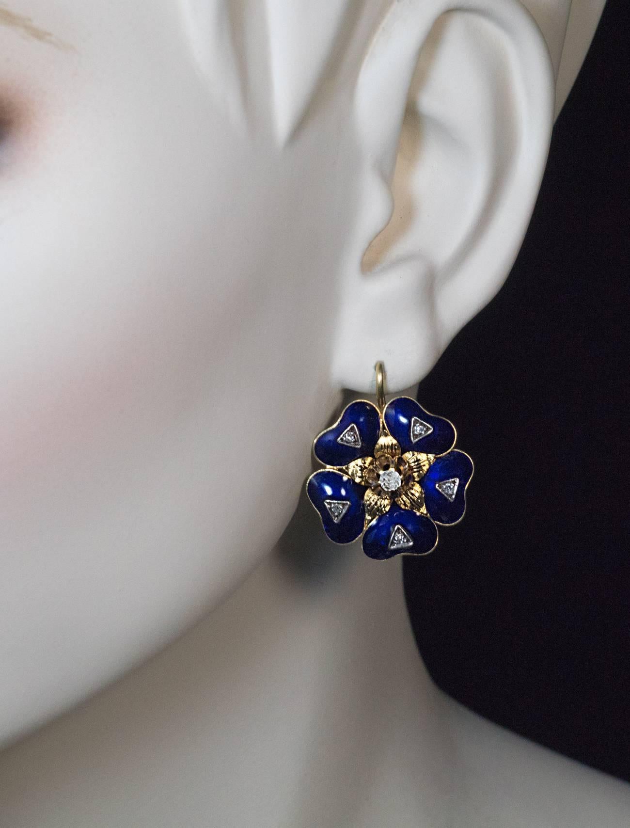circa 1880

18K gold Victorian era earrings are finely modeled as stylized flower heads covered with royal blue enamel and embellished with old mine cut diamonds

total diamond weight 0.35 ct

width 24 mm (15/16 in.)

length with ear wire 29