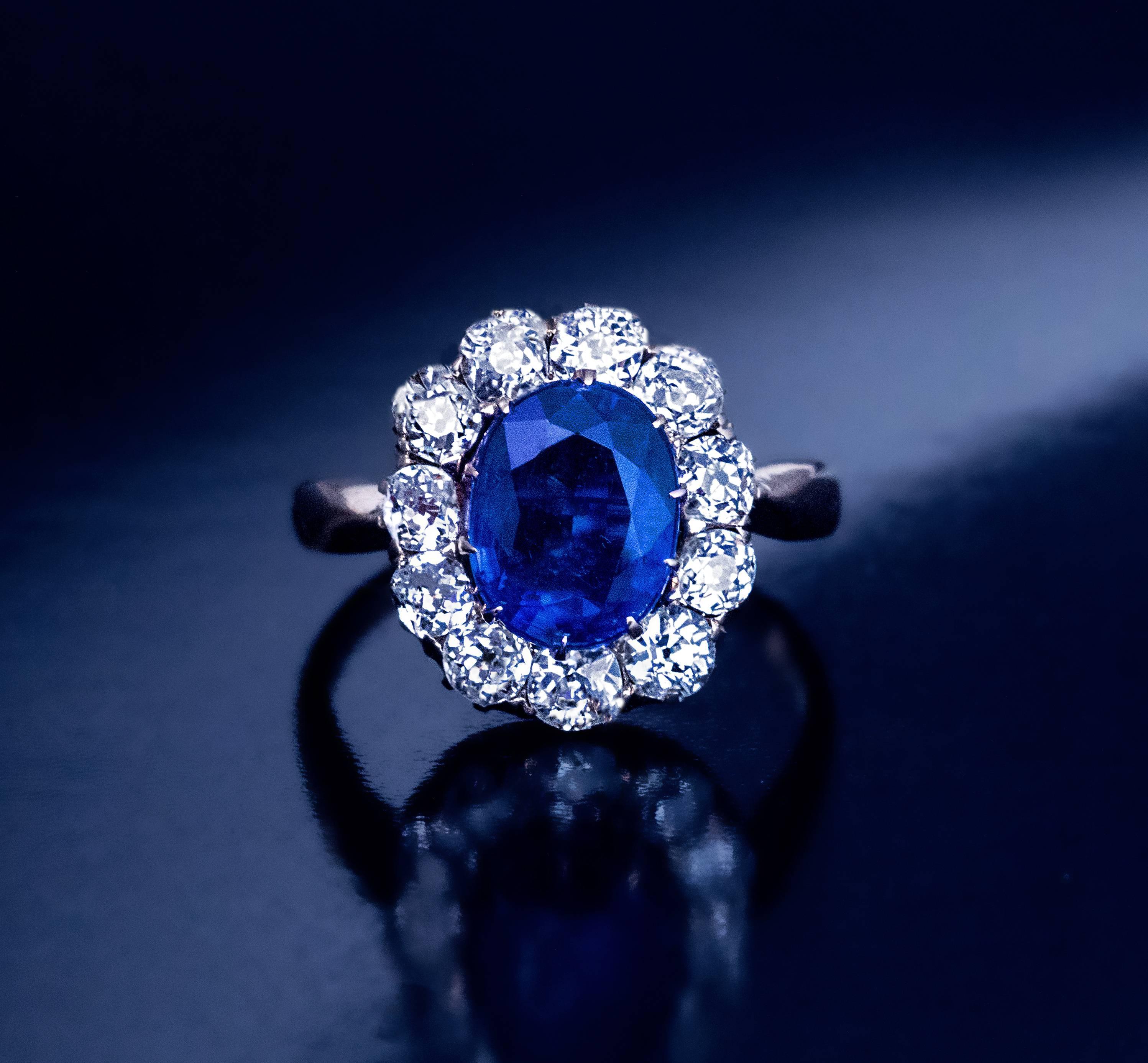 Circa 1910

A 14K gold ring is centered with a cornflower blue kyanite (measuring 9.5 x 7.5 x 4.5 mm, approximately 2.47 ct.) surrounded by 11 sparkling bright white old mine cut diamonds (H-I color, mostly VS clarity).

Estimated total diamond