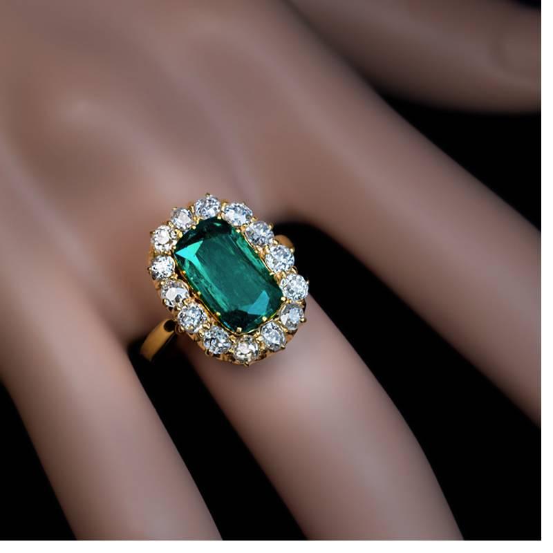 Russian, made between 1899 and 1908
A 14K yellow gold ring features a superb, richly saturated 2.62 ct Colombian emerald of a very nice deep bluish-green color surrounded by 14 sparkling old mine cut diamonds.
Estimated total diamond weight 1.20
