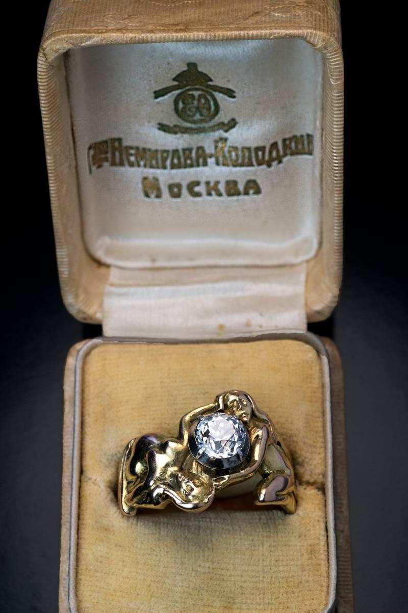 This unique antique ring was made in Moscow between 1899 and 1908 by Nemirov-Kolodkin, a prominent jewelry firm of the period, Court jeweler to Grand Duchess Elizabeth Feodorovna (sister of Empress Alexandra).

The heavy 14K gold ring depicts two