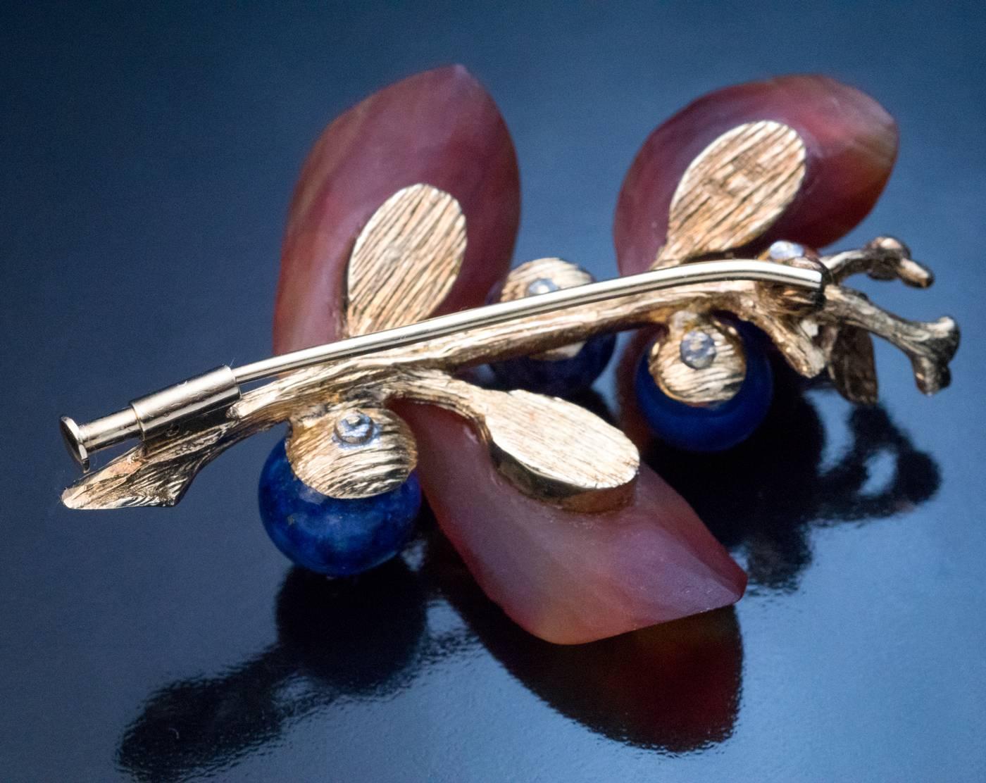 Austrian, Vienna, circa 1950s

The brooch is designed as a textured 14K gold branch with hand carved agate leaves and lapis lazuli berries embellished with diamonds (approximately 0.20 ct total weight).

Marked with maker’s initials, 585 gold