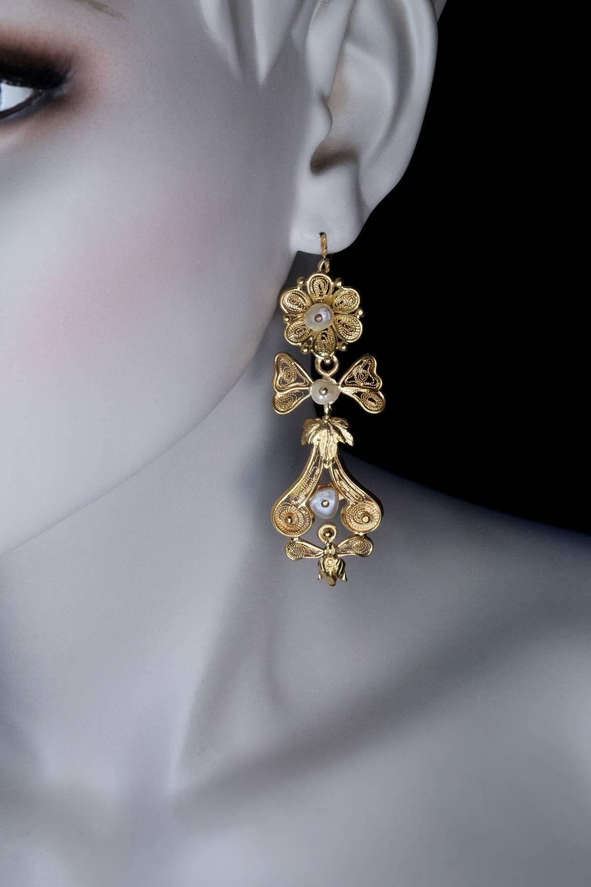 Victorian Greek revival, circa 1880

A pair of brilliantly hand crafted high carat gold (between 20K and 22K ) filigree earrings is designed in ancient Greek style.  The earrings are embellished with six fresh water pearls.

Weight 10.84 and 10.80