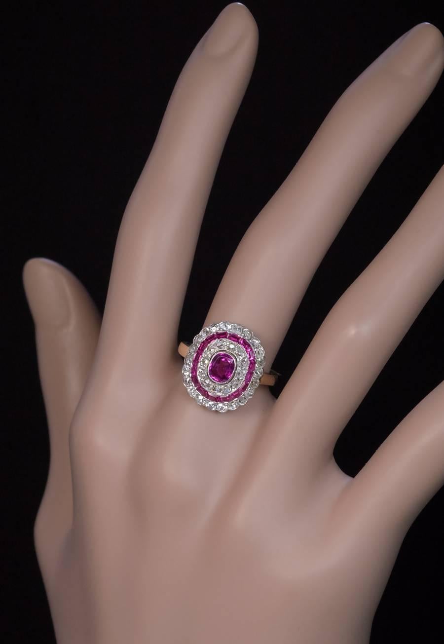 Polish, made in Warsaw between 1920 and 1931

A platinum over 14K gold cluster ring is centered with a natural pink sapphire (5.4 x 4.7 x 2.65 mm, approximately 0.60 ct) surrounded by two rows of old mine cut diamonds separated by a row of calibre