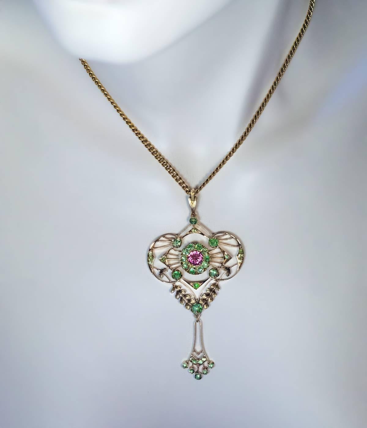 Made in Moscow between 1908 and 1917

A 14K rose and green gold openwork pendant in Russian Modern style of the 1910s (with both elements of Art Nouveau and Edwardian Garland style) is embellished with green Russian demantoids and a pink