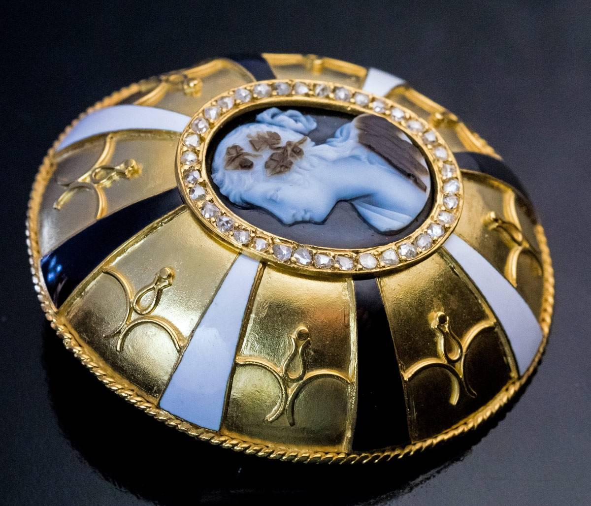Circa 1880

A Renaissance style large 18K matte gold brooch is centered with a carved agate cameo of a profile female bust framed by numerous rose cut diamonds and surrounded by gold filigree festoons and black & white opaque enamel rays.

The