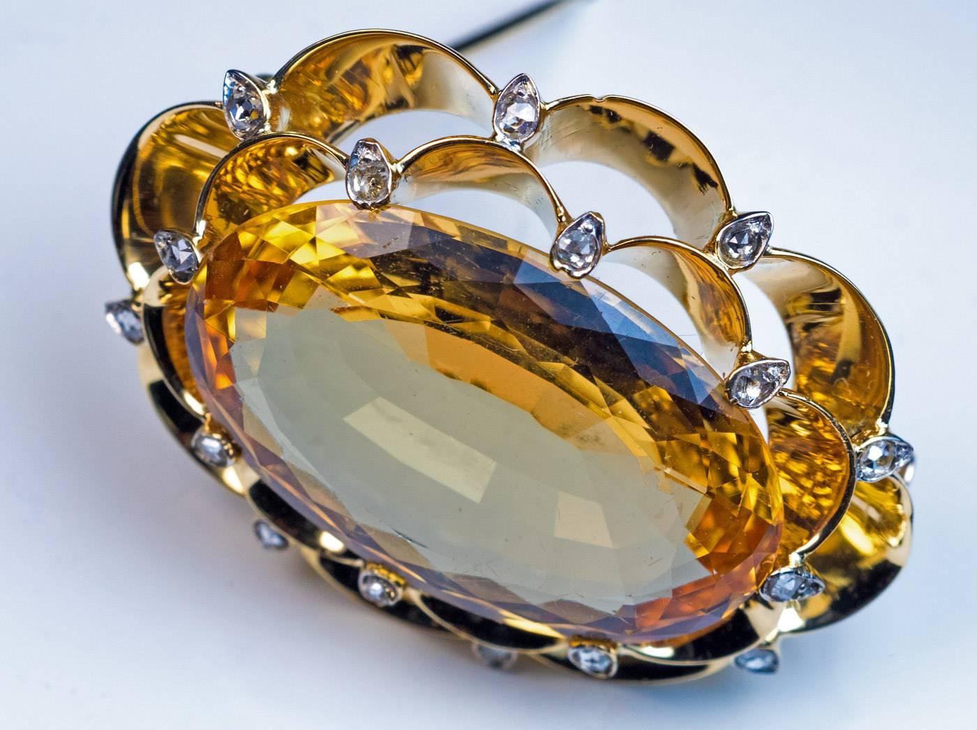 Made in Moscow in the 1930s

An Art Deco 14K gold brooch features a huge and very rare Russian precious Imperial topaz from the Ural Mountains set in a scalloped double frame embellished with old rose cut diamonds. The stone has a golden orange