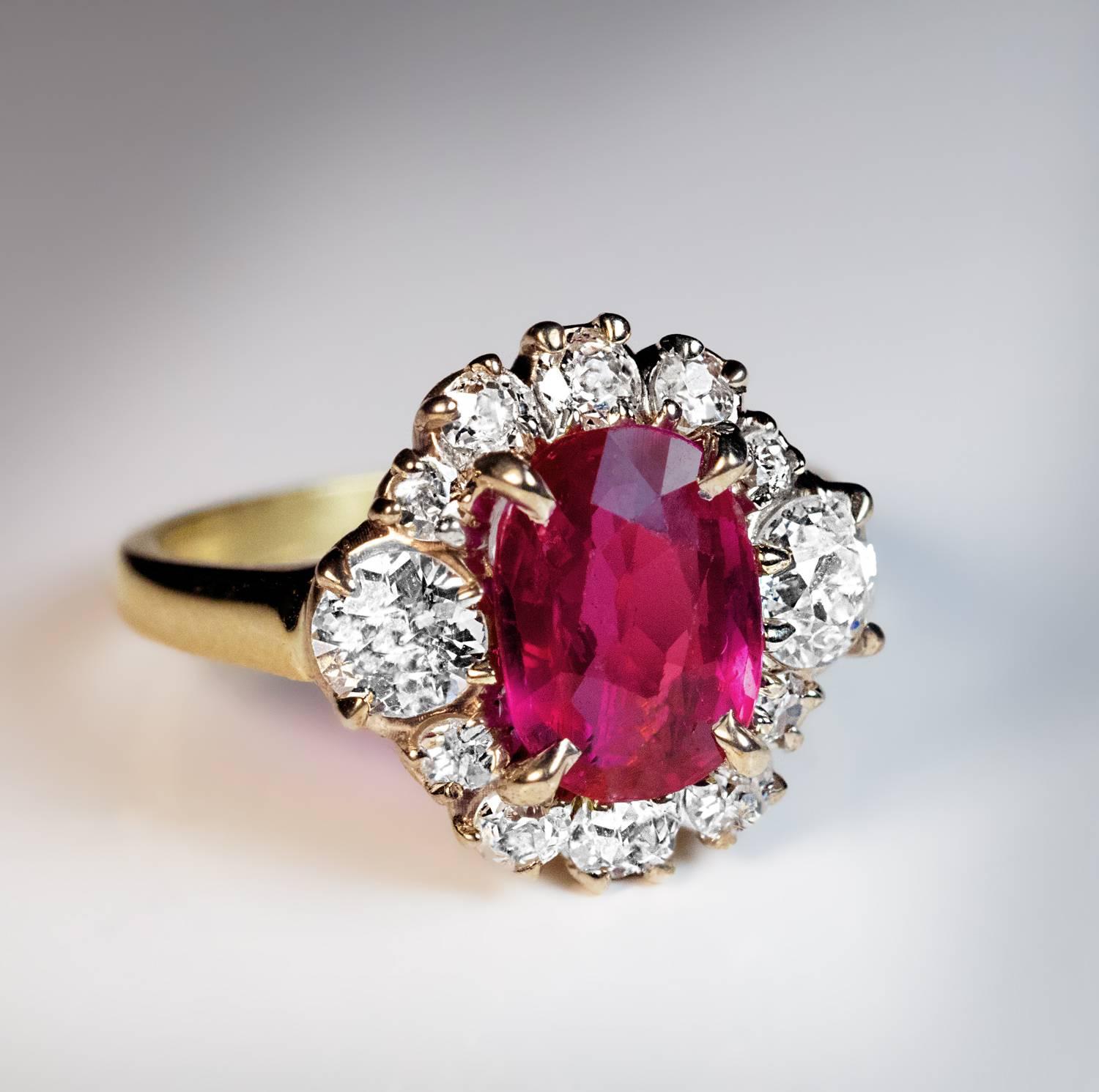 A silver topped 18K gold ring is centered with an oval natural unheated pink-red 2.71 ct ruby from Burma (Myanmar). The ruby is framed by bright white (F-G color) old mine cut diamonds (estimated total weight 1.25 ct).

The ring comes with AGL