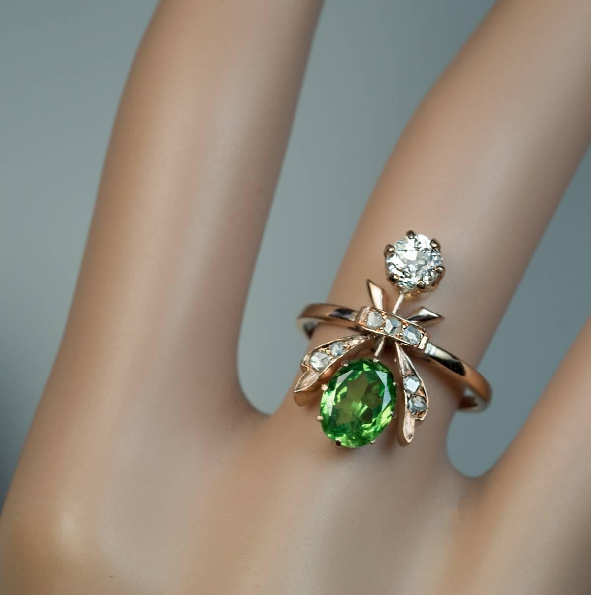 Russian, made between 1899 and 1908

A 14k gold ring is designed as a stylized flower or a fly. The ring is set with one 1.22 ct Russian demantoid of excellent color and clarity, one old European cut diamond (4.4 – 4.6 x 3.4 mm, approximately 0.43