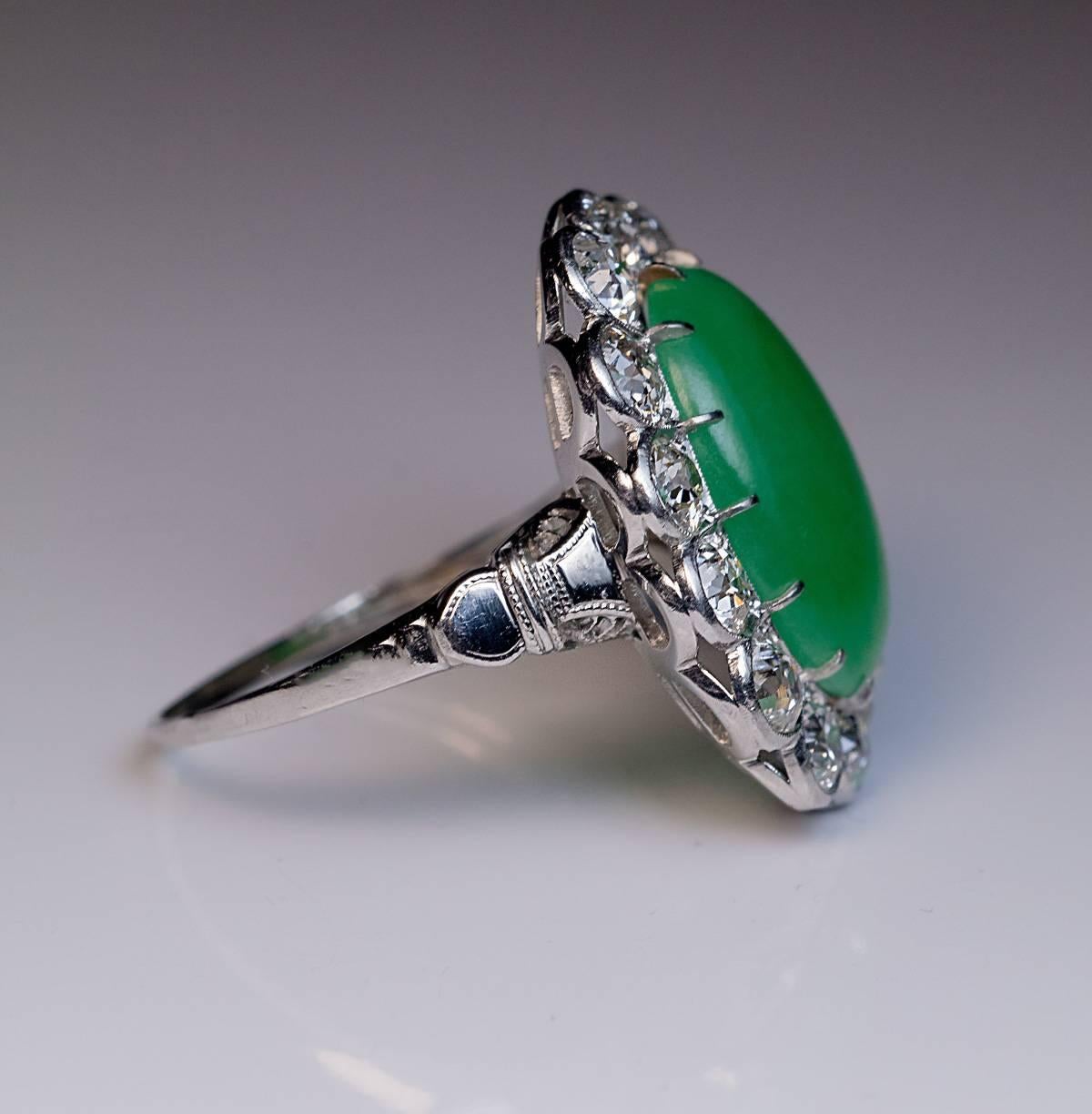 Circa 1925

An 18K white gold ring features a large cabochon cut natural jadeite jade of a soft green color (measuring 16.78 x 11.62 x 4.85 mm, approximately 8 carats) encircled by 14 sparkling old European cut diamonds.

Estimated total diamond