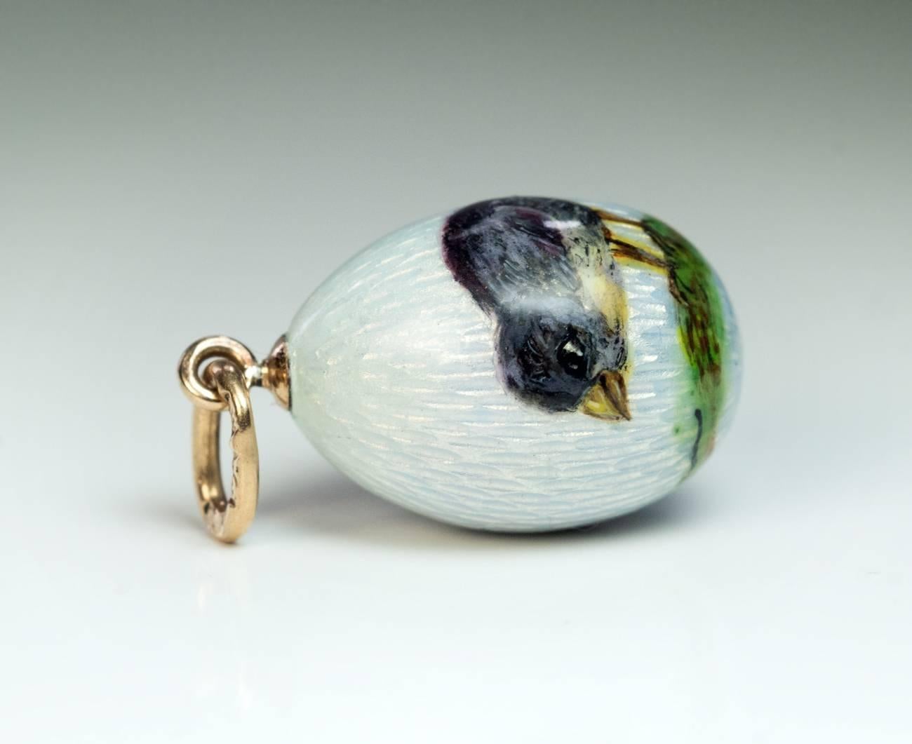 Made in St. Petersburg between 1908 and 1917
A rare original pre-1917 FABERGE miniature egg pendant is covered with a very fine pale blue guilloche enamel. One side of the egg is painted enamel of a bird standing on grass.
The egg is marked on its