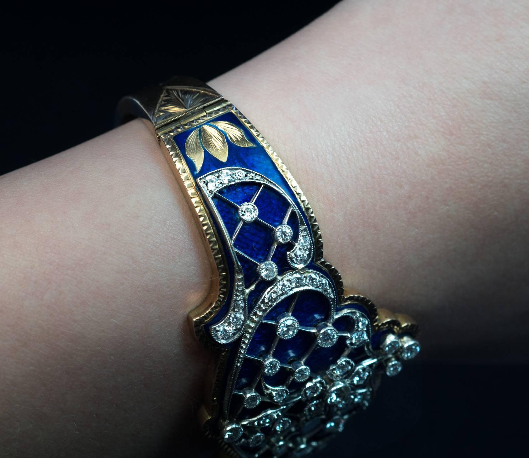 Circa 1910
A very fine quality 14K gold bangle bracelet is embellished with an elaborate platinum and diamond openwork design applied over a royal blue guilloche enamel ground. The sides of the bracelet are hand-engraved with stylized flowers.

The