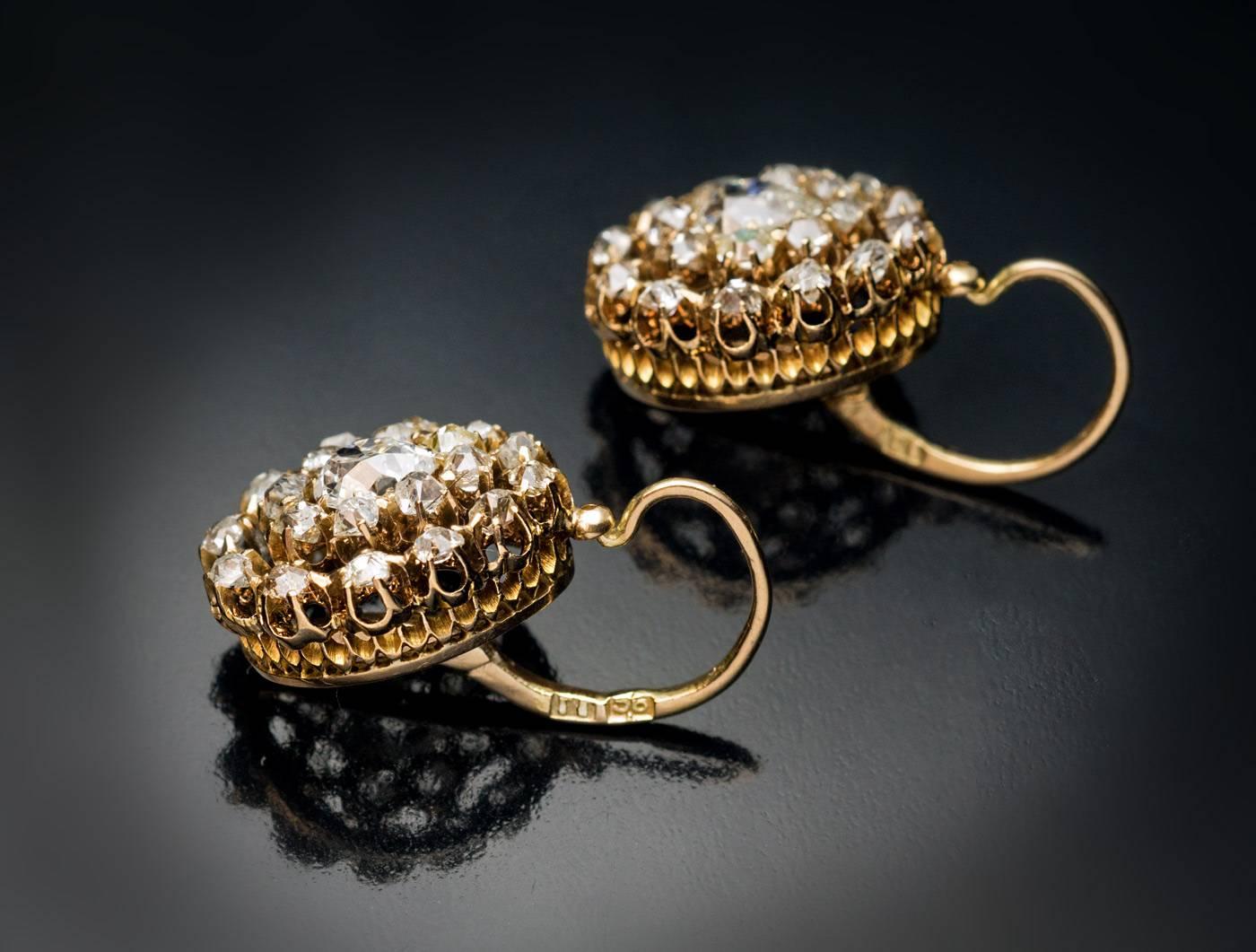 Antique Russian 14K gold drop earrings are set with approximately 3 carats of sparkling bright white old cut diamonds.

Each earring is centered with an old pear cut diamond surrounded by two rows of graduating old mine cut diamonds. The pear cut