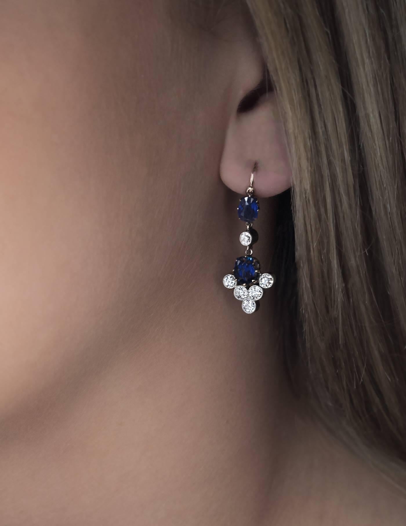 This pair of Russian 14K gold and silver pendant earrings was made in the 1890s.
Each earring is prong-set with two cushion cut sapphires and six old European cut diamonds set in silver bezels.

Estimated total sapphire weight is 3 carats.