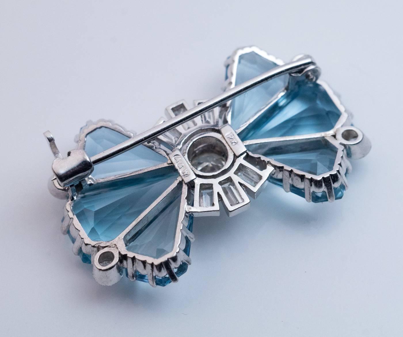 Circa 1935
A vintage platinum bow-shaped brooch / pin is set with aquamarines, round and baguette cut diamonds (H color, VS1 – SI1 clarity).

Estimated total aquamarine weight is 10 carats.
Approximate total diamond weight is 1 carat.

Width 30 mm