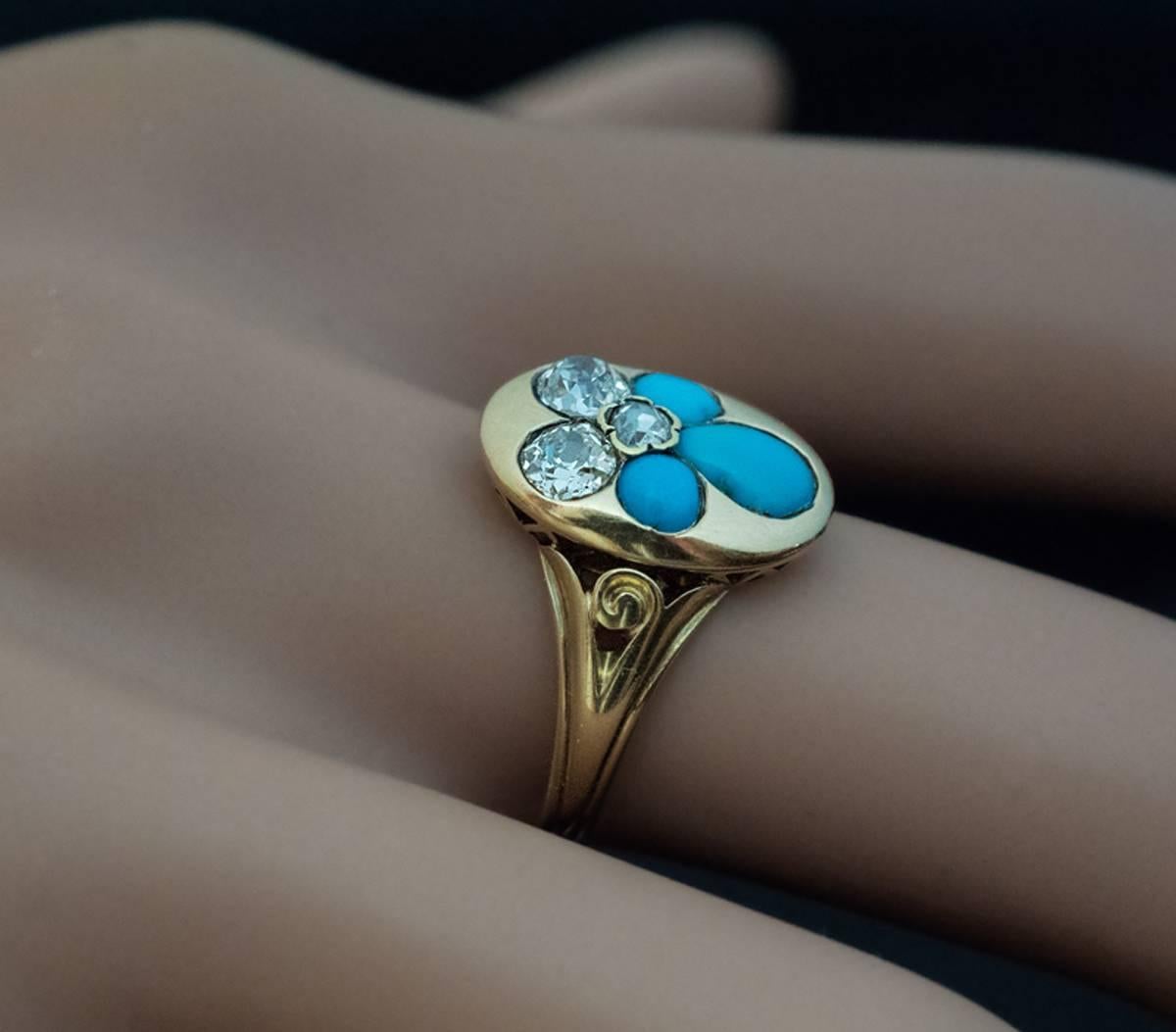 This sentimental antique ring from mid Victorian era was made in St. Petersburg in 1865.  The 14K gold ring features a stylized forget-me-not set with cabochon cut turquoise, two old cushion cut diamonds, and one rose cut diamond. The flower is