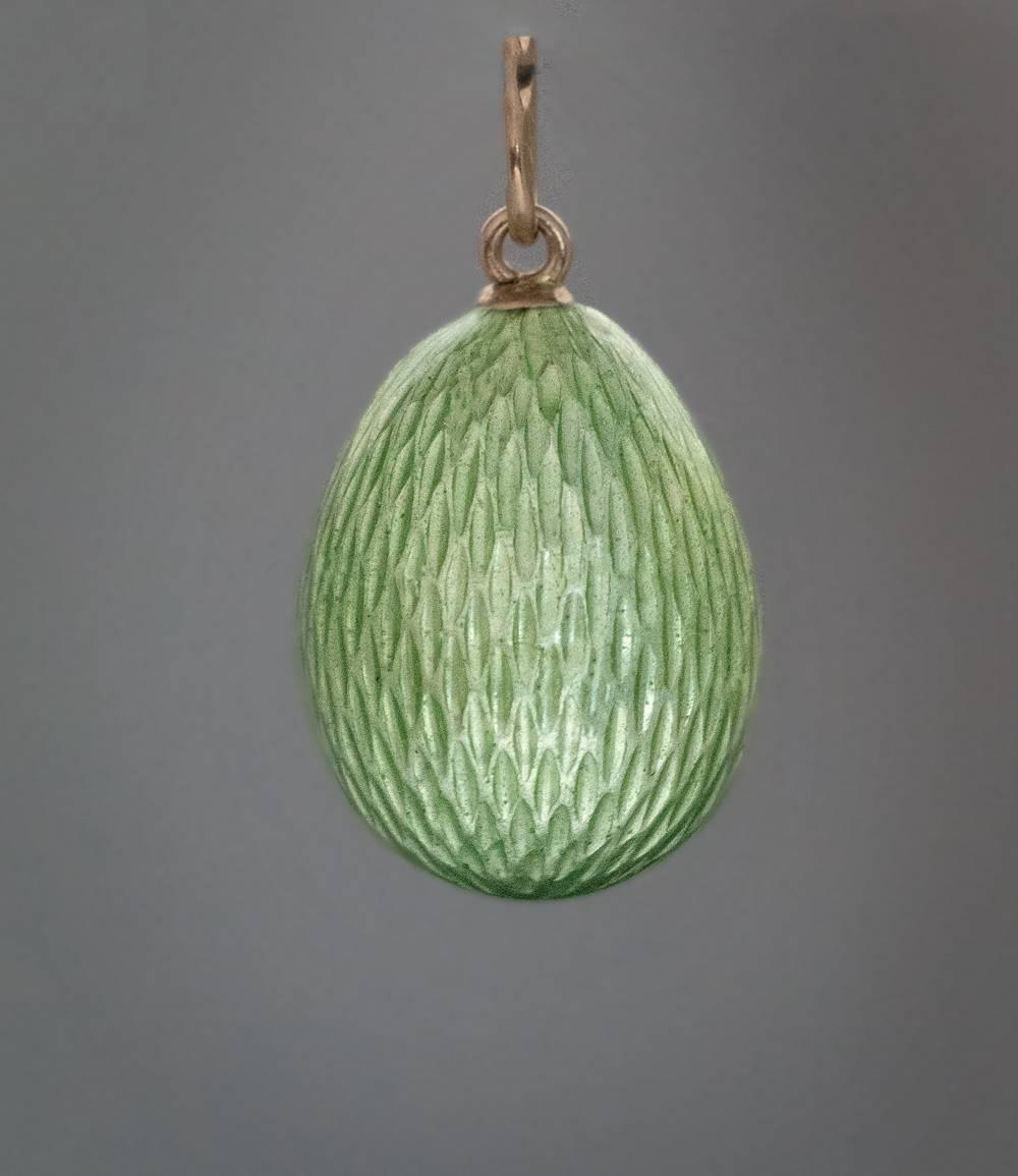 Made in St. Petersburg between 1908 and 1917
A gold mounted miniature egg is covered with pale apple green guilloche enamel. One side of the egg is finely enameled with a hen hatching eggs in the nest.
The egg is marked with 56 zolotnik Imperial