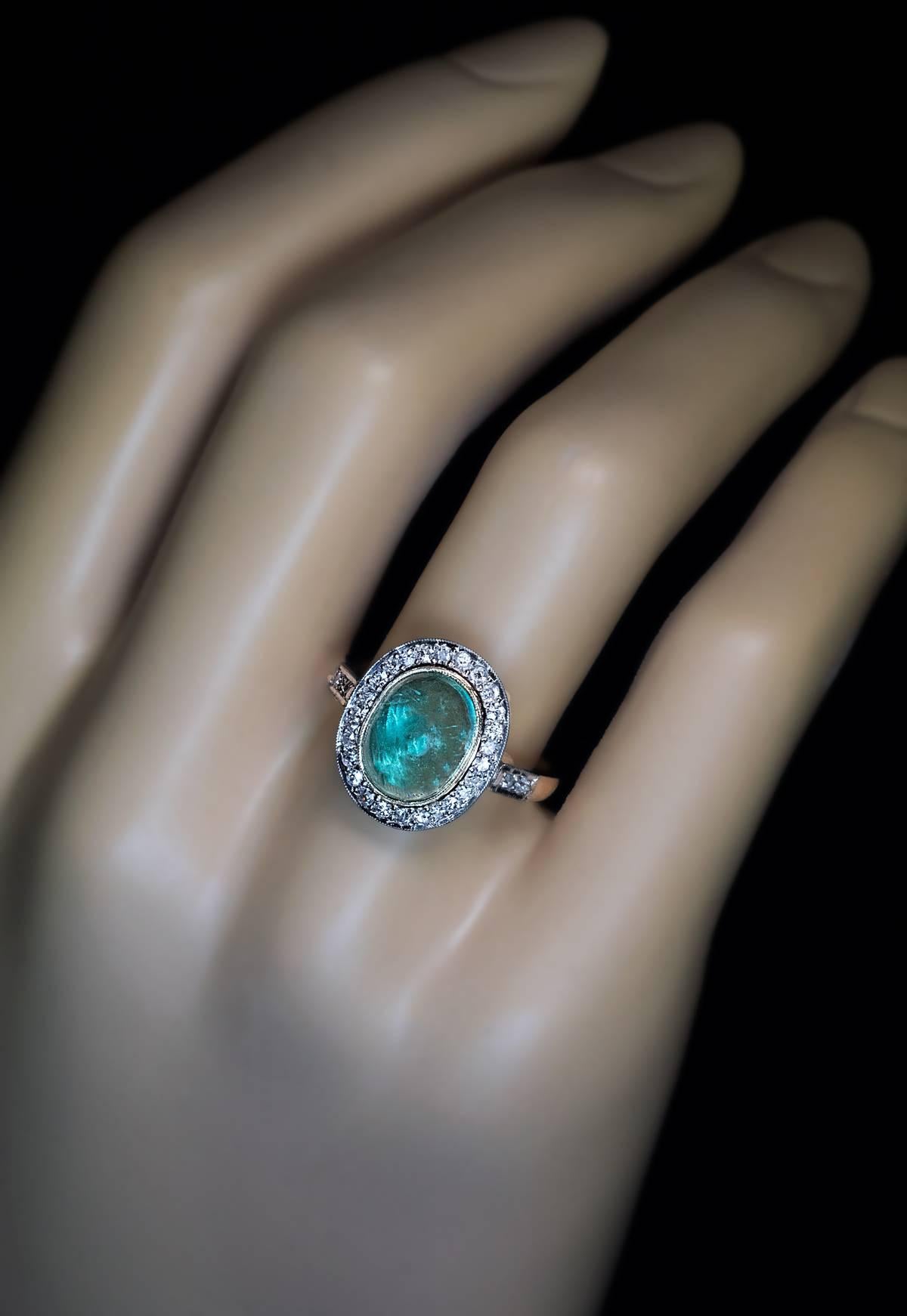 1950s
A vintage Russian ring is handcrafted in white, yellow, and rose 14K gold. The ring features a cabochon cut pale bluish-green emerald framed by old single cut diamonds.
The emerald measures 10.5 x 8 x 4.9 mm and is approximately 3.08