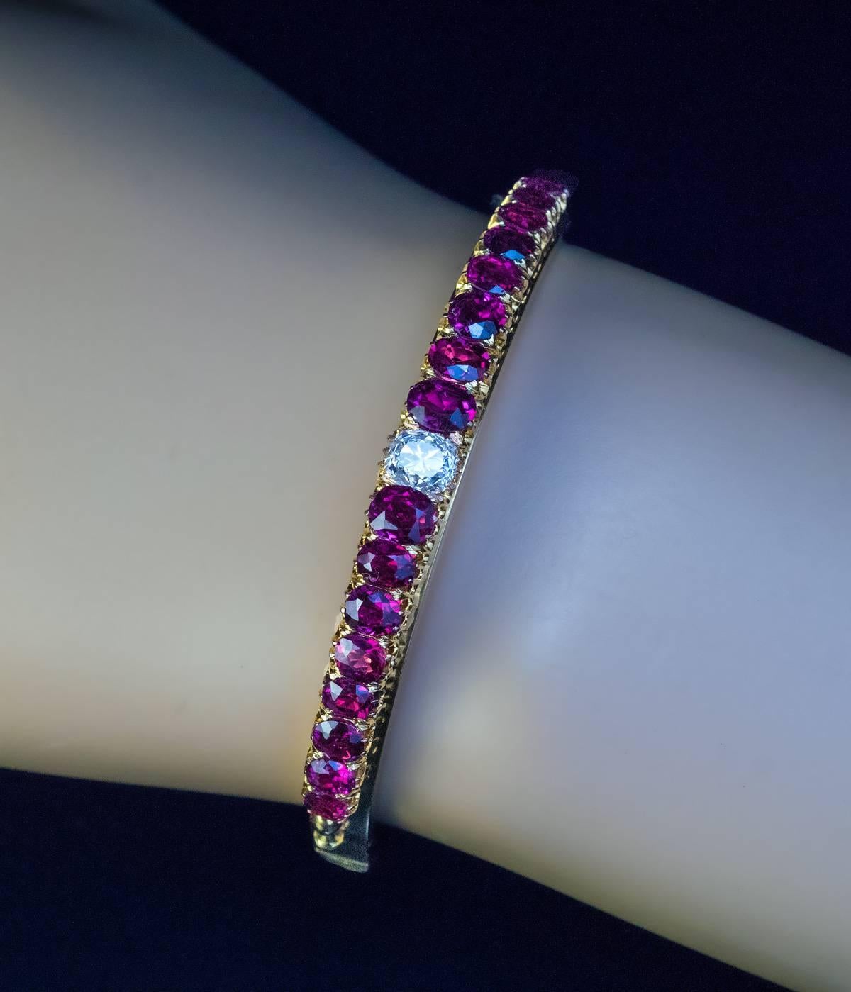 Russian, made in St. Petersburg in the 1890s
An antique 14K gold bangle bracelet is centered with an old cushion cut diamond (5.8 x 4.9 mm, approximately 0.90 ct, H color, VS2 clarity) flanked by well-matched cranberry red Thai rubies (estimated