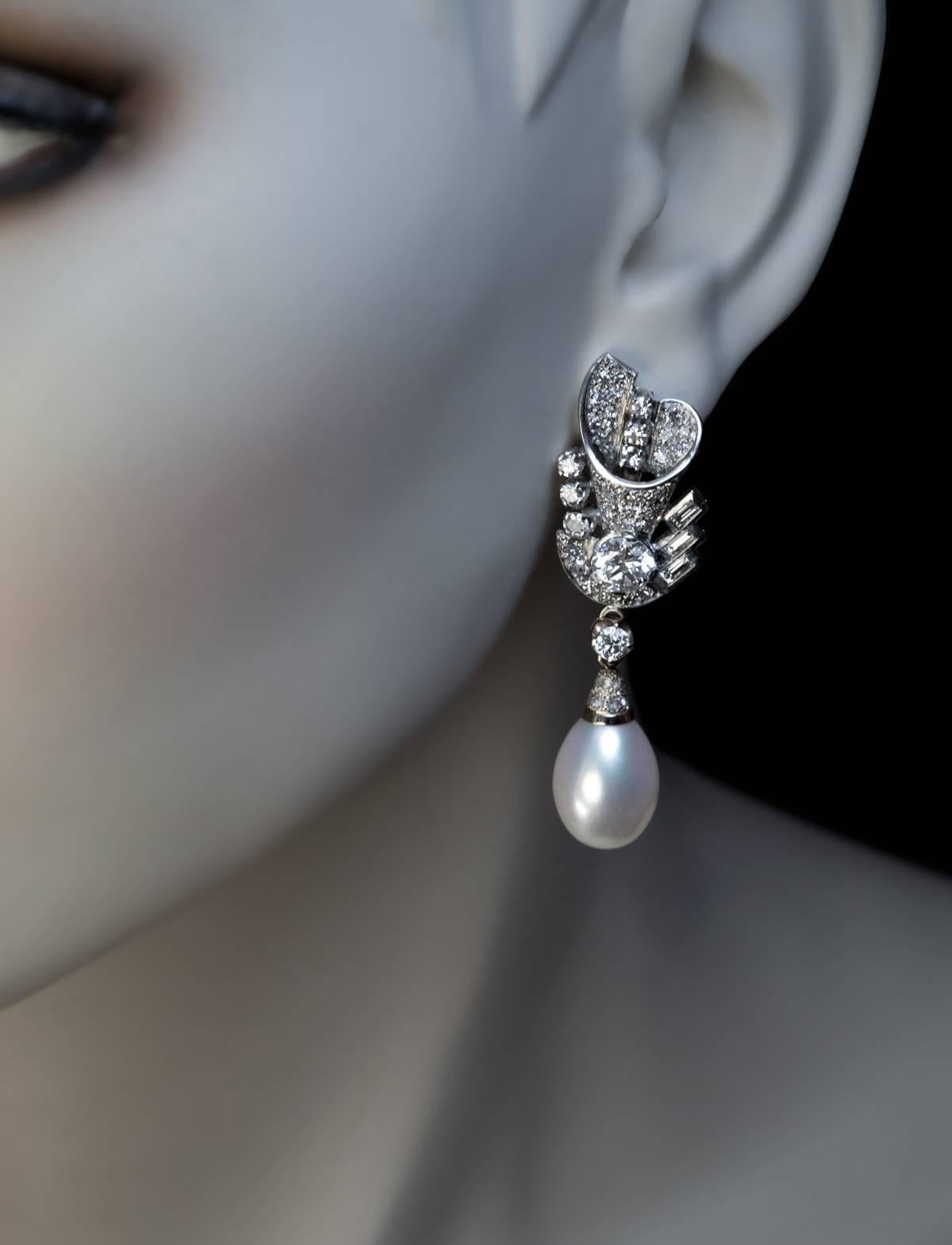 Spätes Art déco, um 1940
Diese prächtigen Ohrringe sind aus weißem und blassgelbem 14-karätigem Gold gefertigt und mit alten europäischen Diamanten im Einzel-, Baguette- und Altrosaschliff besetzt. Die beiden Hauptdiamanten sind strahlend weiße und