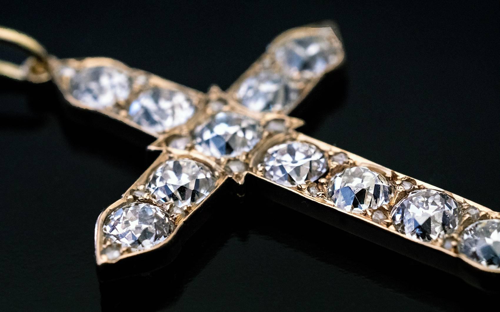 Made in St. Petersburg between 1908 and 1917
This antique 14K gold cross is set with 11 sparkling bright white old European cut diamonds of uniform color (F-G) and clarity (VS2-SI1) and is accented by 20 tiny rose cut diamonds.
The chunky old
