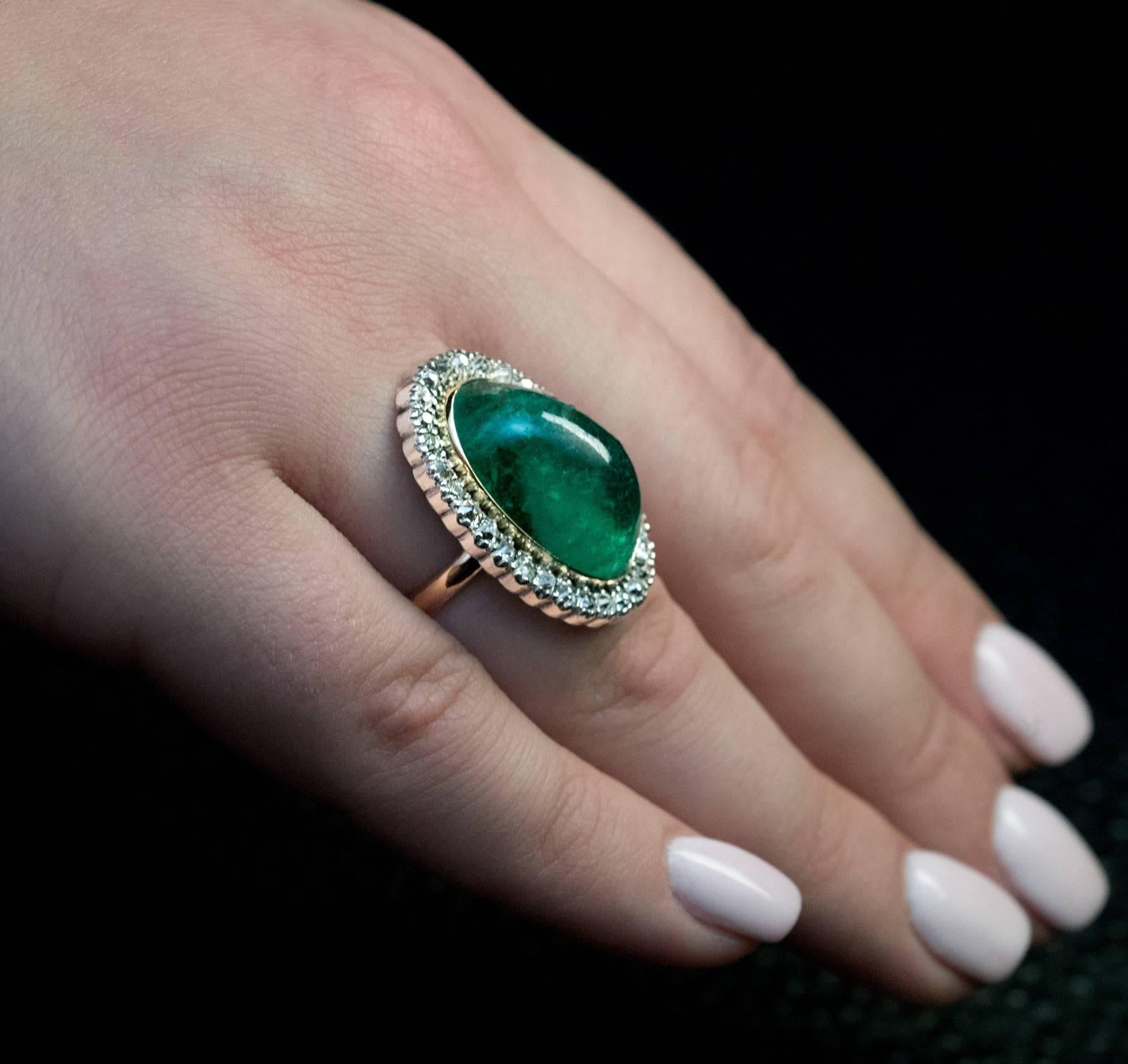 early 1900s
This antique 14K gold and silver ring features a cabochon cut emerald (measuring 21.2 x 13 x 9.25 mm) of a nice bluish green color. The emerald is framed by old cushion cut diamonds (H-I color, SI clarity) set in silver over gold.