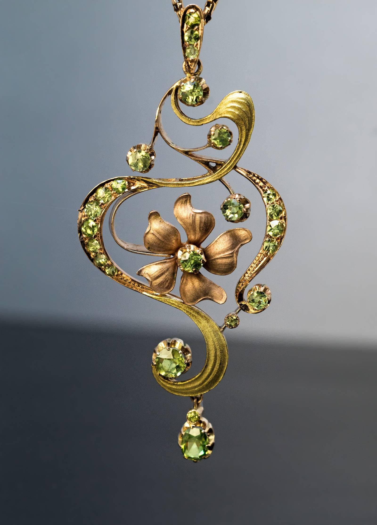 Made in Moscow between 1899 and 1908

An antique 14K rose and green gold pendant is designed in Art Nouveau taste as a stylized flower. The pendant is embellished with sparkling bright apple green Russian demantoid garnets.

The pendant is marked