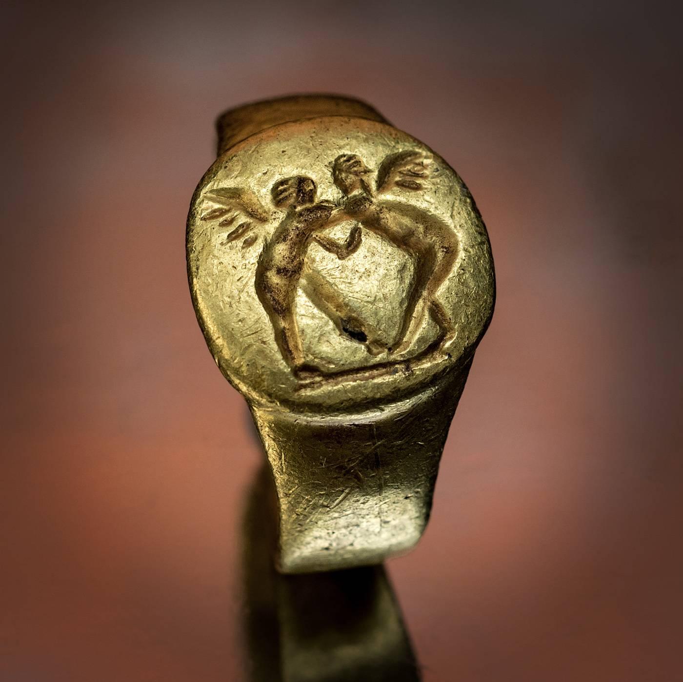 A unique, museum quality ancient Greek gold ring, circa 4th century BC, likely a wedding ring.

The ring is engraved with two wrestling Erotes. When Aphrodite (Greek goddess of love, beauty and pleasure) was born from the sea she was greeted by the