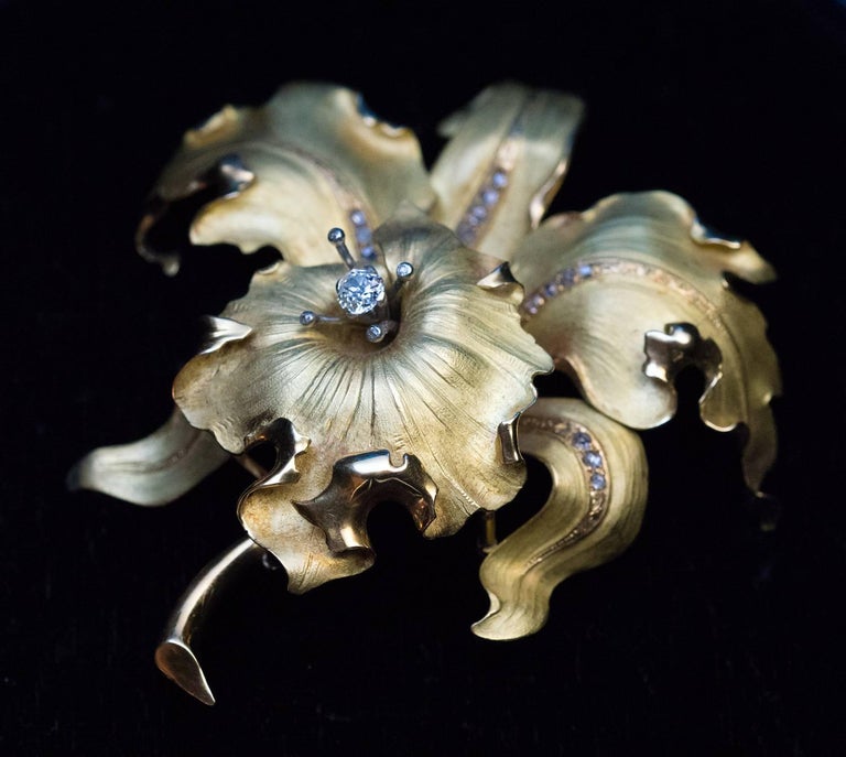 Circa 1910

This very large antique matte and polished green 18K gold brooch is superbly modeled as a stylized orchid embellished with numerous old rose cut diamonds and one cushion cut diamond (approximately 0.60 ct).

Width 82 mm (3 1/4