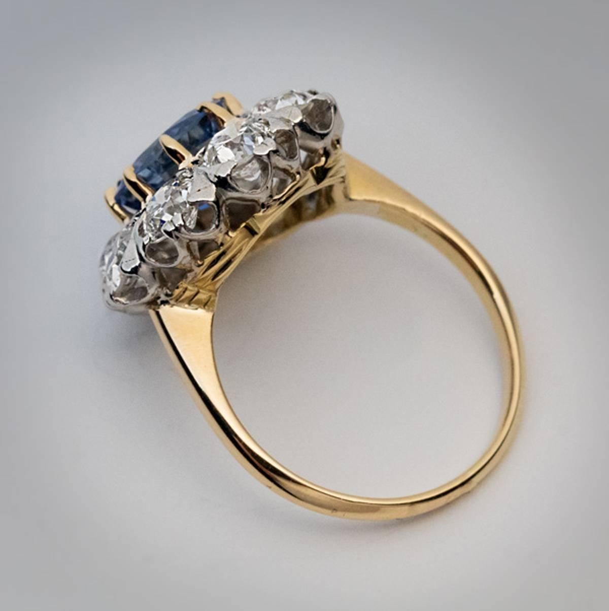 Circa 1910

An antique 18K gold and platinum engagement ring is centered with a 2.24 ct natural blue sapphire surrounded by sparkling bright white old European cut diamonds (G-H color, VS2-SI1 clarity). Estimated total diamond weight is 2.40 ct. The
