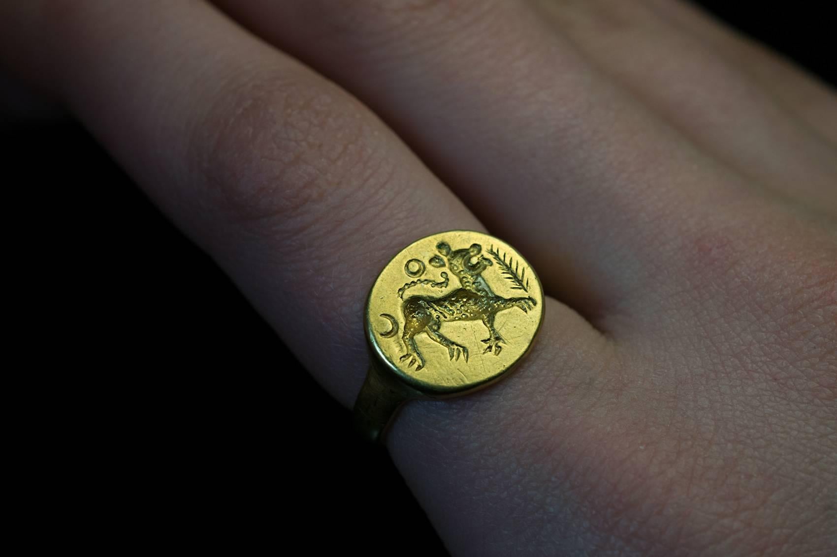 An ancient solid gold signet ring, eastern Roman Empire, circa 2nd century AD. The bezel is engraved with a leopard walking to the right, flanked by a crescent moon and a palm leaf, a sun above.

This very rare and unusual ring is perfectly
