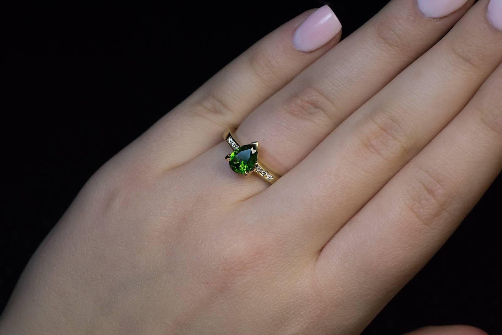 A contemporary 18K gold ring is centered with a grass green 1.45 ct pear cut Russian demantoid garnet flanked by bright white (F color) diamonds.

The demantoid has some fine “horsetails”, a unique feature of demantoids mined in the Ural