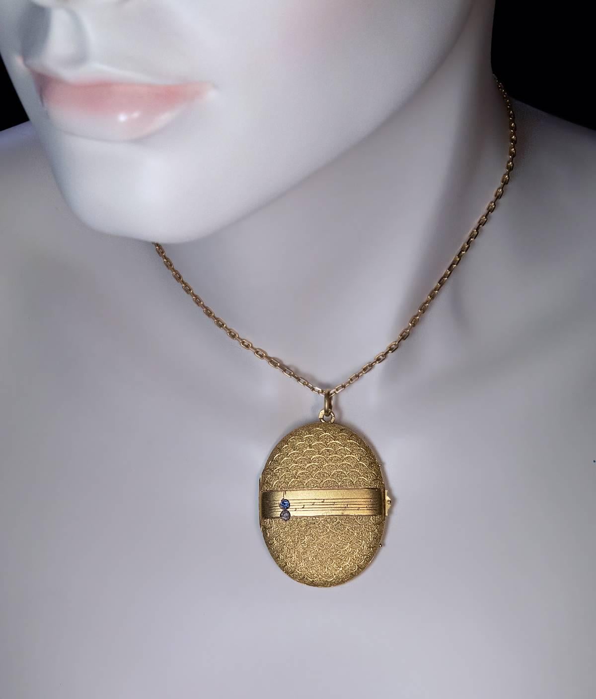 Russian, made in Odessa between 1908 and 1917

The front cover of this unusual locket is engine turned in a fish scale pattern with a matte gold band across the center.

The band is hand engraved with musical notes and embellished with a diamond
