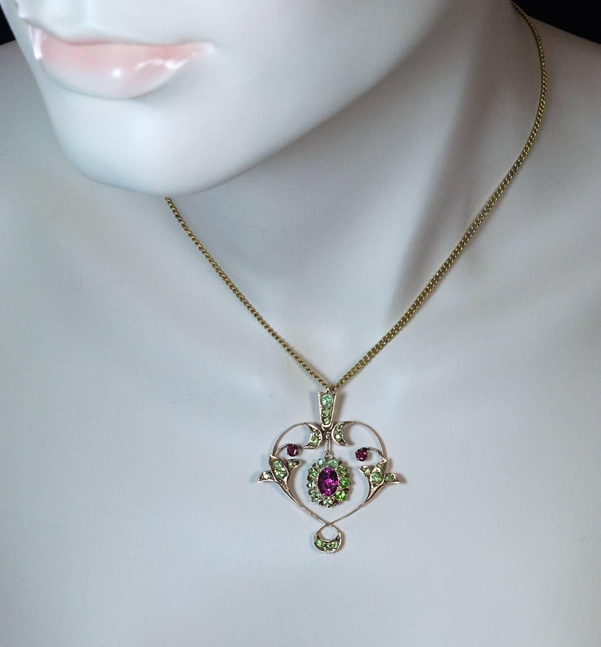 Russian, made in Kazan between 1899 and 1908

The 14K gold pendant of an Art Nouveau floral design set with a hot pink tourmaline, 27 sparkling apple green Russian demantoids and two red spinels.

42 mm (1 5/8 in.) high,  36 mm (1 1/2 in.)