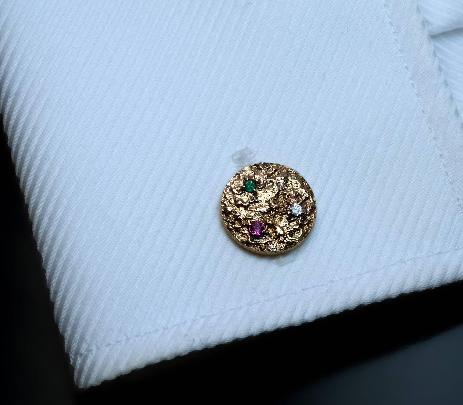 The 18K gold cufflinks with textured surface resembling a gold nugget are set with two old cut diamonds, six colored spinels, one opal and one pearl.

Diameter 15 mm (9/16 in.)