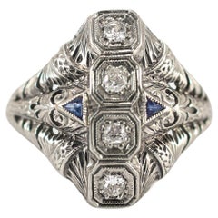 Bague cocktail Art déco ancienne filigranée en or blanc 18 carats avec quatre diamants et saphirs