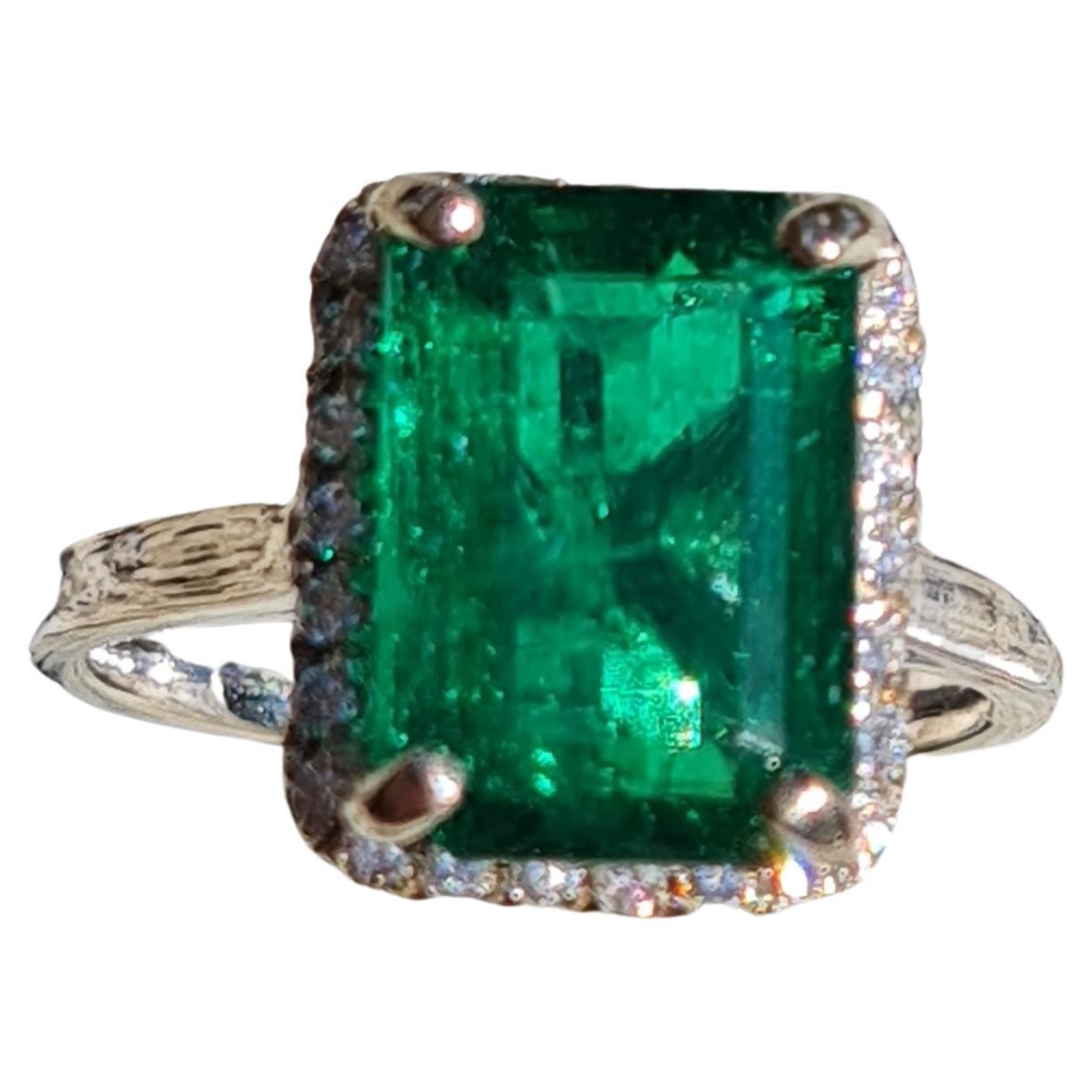 This is a very nice ring. It is brand new casting from Stuller with around 1/2 ct of 1.3-1.4mm diamond; all VS and clear. The center stone is a 4.54 CT Octagonal Step Cut. An extremely rare Emerald from Zambian, with virtually no noticeable