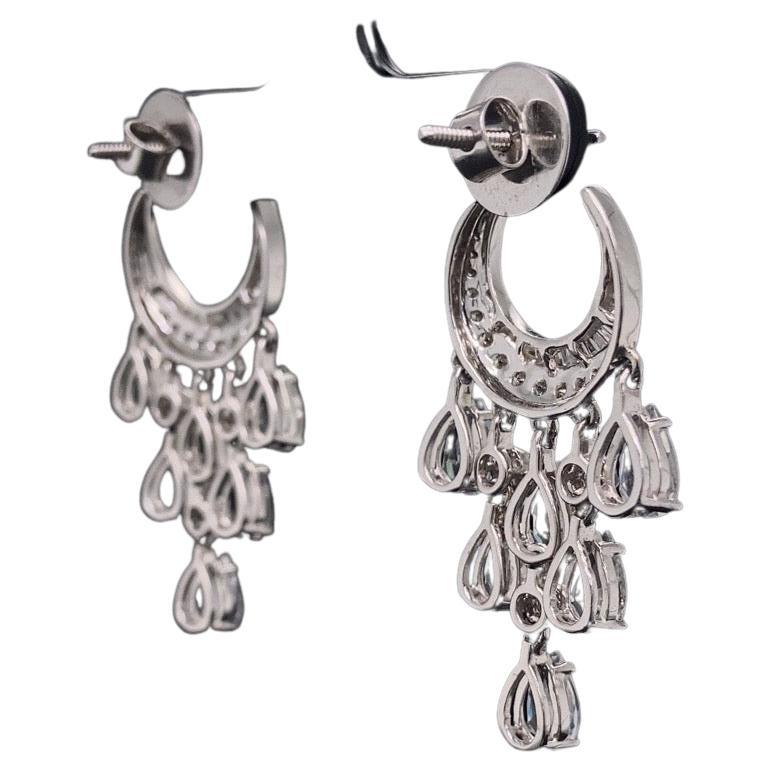 These earrings are stunning piece of jewelry that features a beautiful combination of diamonds and white sapphires. The earrings are made of 18K solid gold and have a natural diamond as well as a rose-cut pear-shaped white sapphire. The diamonds are