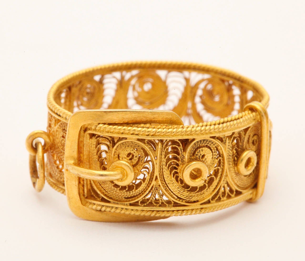 A  lace like band, created in 18kt gold way back at the brink of the Victorian era in Europe, is as beautiful today as the day it was made.  The golden filigree wraps around the band like ferns that are held on the finger with a buckle and strap.