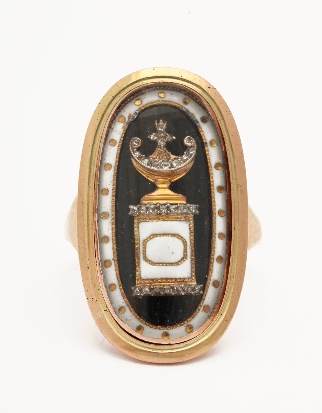 This 15kt Memento Mori touches the heart with its beauty and with its story. An oval bezel holds a crystal that covers the black and white enamel as well as the glistening diamonds and gold below. The artists sense of symmetry is apparent in the