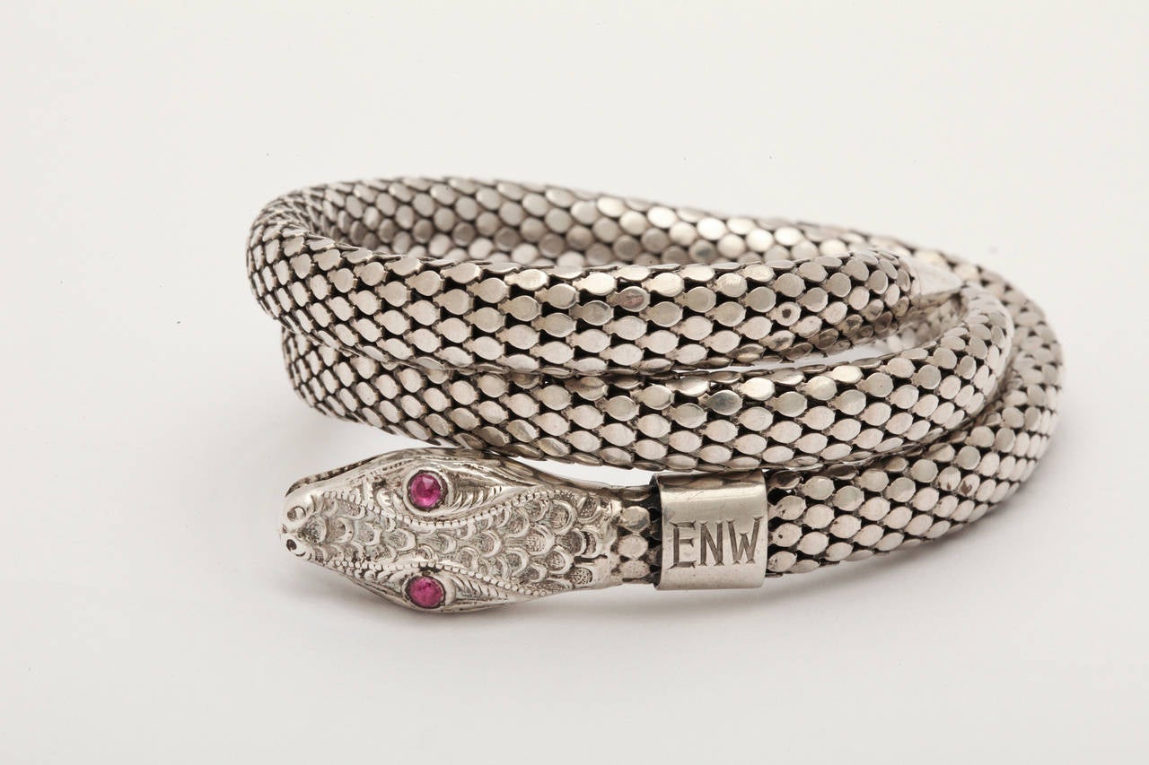 Calm at the moment, our sterling silver serpent has ruby eyes and will happily wrap around your wrist or arm in comfort. Admire the engraving on this bracelet with the head detail in proportion to the body scales. 
The serpent is an ancient
