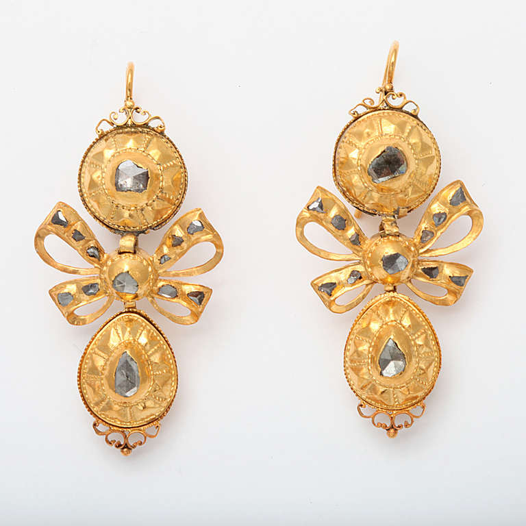 Imagine gold lit by the light of a candle and you will know the color of this pair of high karat gold and foiled antique rough cut diamonds typical in form of the pendeloque chandelier earrings made in Portugal in the 18th century. This pendeloque
