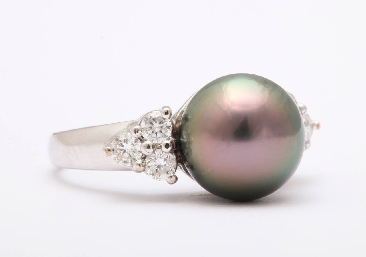 Stare into the eye of this luminous pearl and diamond ring and be hypnotized by the magic of the natural color. and the elegance of the jewel. The setting places the 12mm pearl on a pedestal to be constantly admired and though it needs no