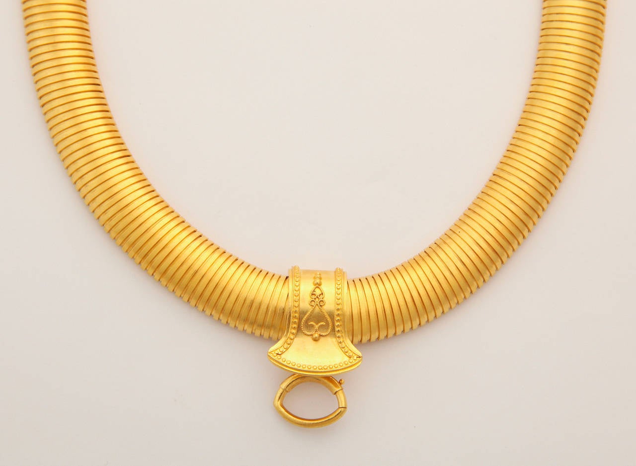 An ultra flexible, even stretchy, ultra wide Victorian snake chain collar in 18kt bloomed gold so gleaming that it is almost iridescent, is joined by a slide that slips off when desired. I first viewed this necklace without the slide and