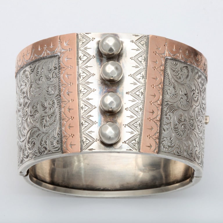 Heraldic engraving on gold and silver emphasizes the corset form centered by four silver orbs that suggest where the lacing connects. Tightly engraved fern scrolls cover the remainder of the front of this extraordinary cuff, a rare example of