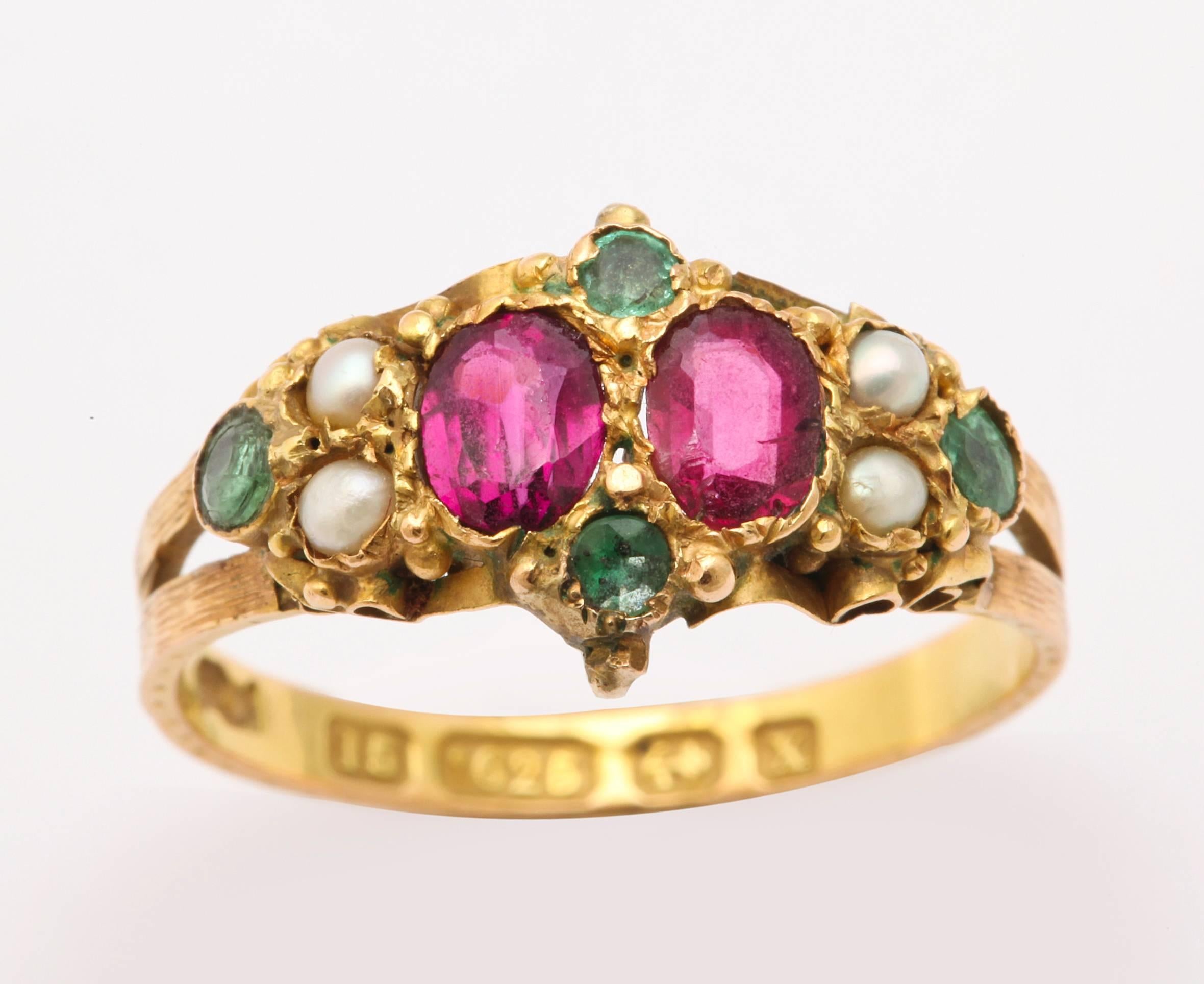 Luscious colors of ruby, emerald and pearl are marvelous neighbors in this Victorian 15kt gold ring c. 1840. The gems are foiled as was the manner at this time. The colors, nonetheless are intense. The bifurcated shank is ridged and narrows to a