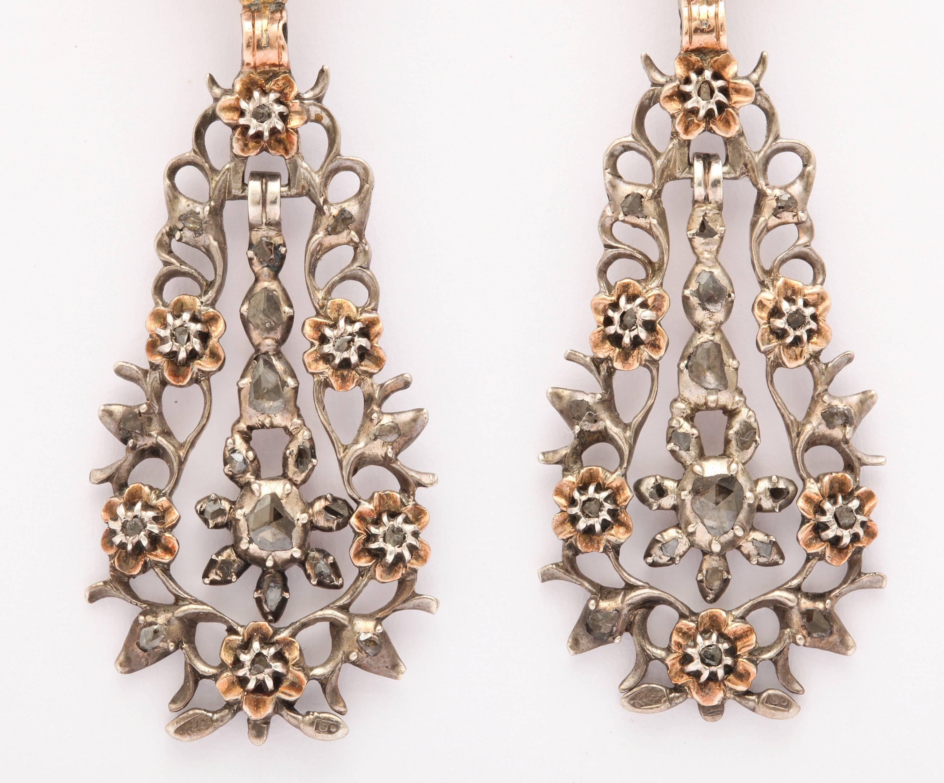 The diamonds are sparkling dewdrops throughout these lightweight, spiky, lacy Georgian earrings set with antique gems and punctuated with gold flowers. The flowers hold small diamonds in their center. This is one of a pair of the most luscious